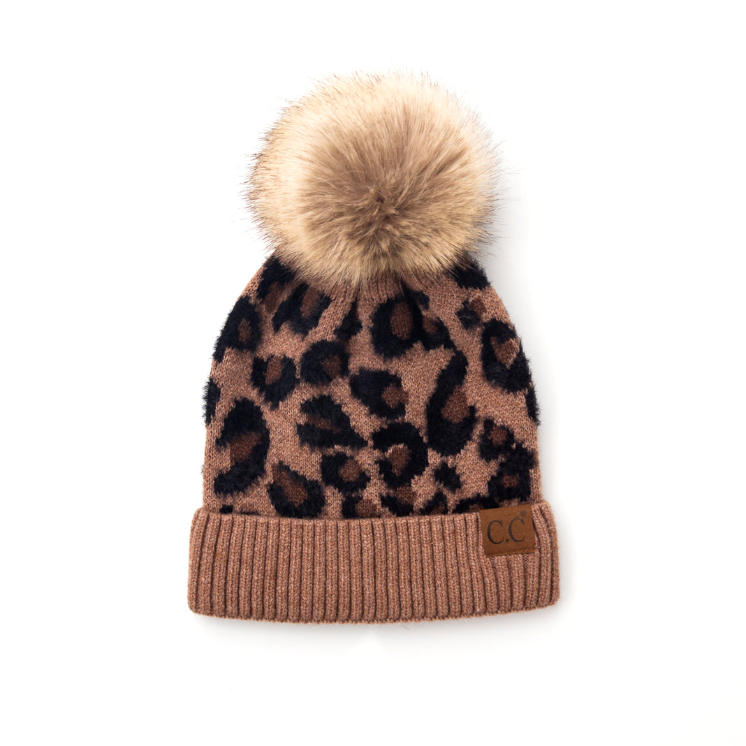 Brown and black leopard-print pom beanie on a white background.