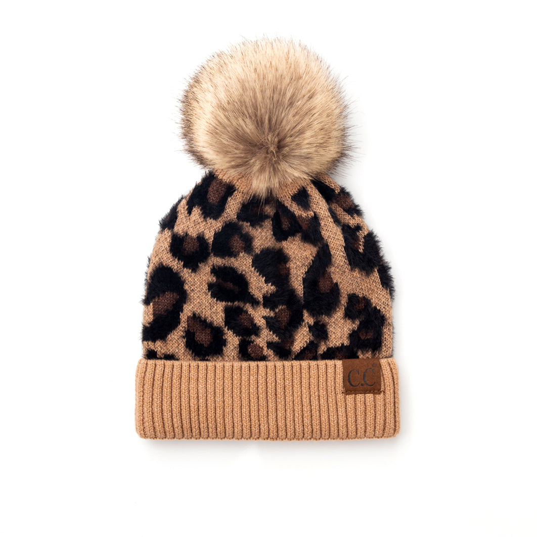 Tan and black leopard-print pom beanie on a white background.