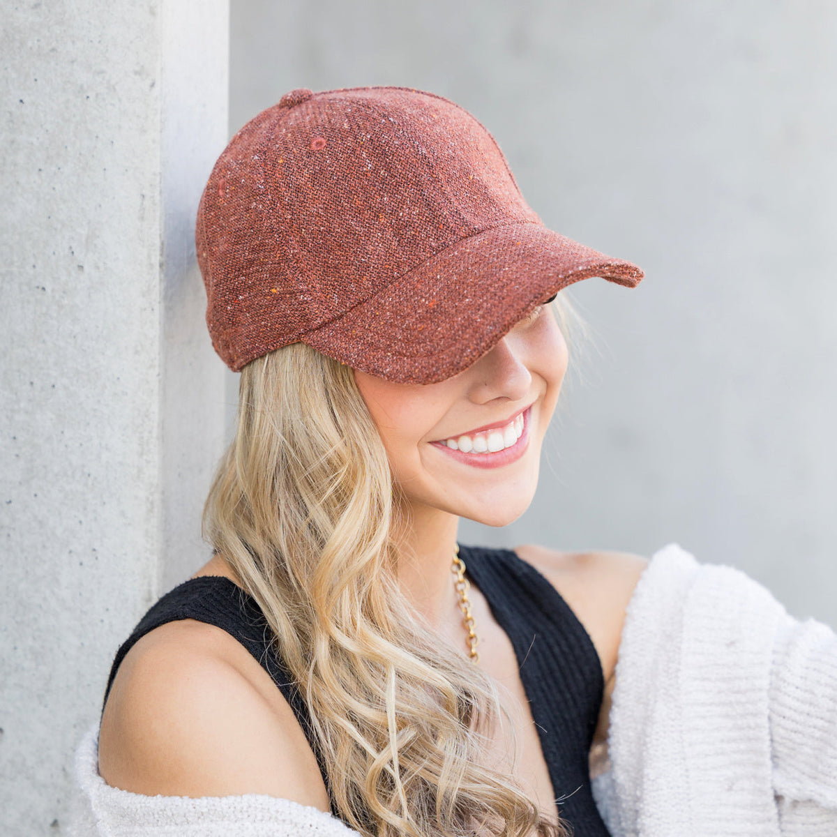 Rust-colored tweed-style baseball cap worn on a model.