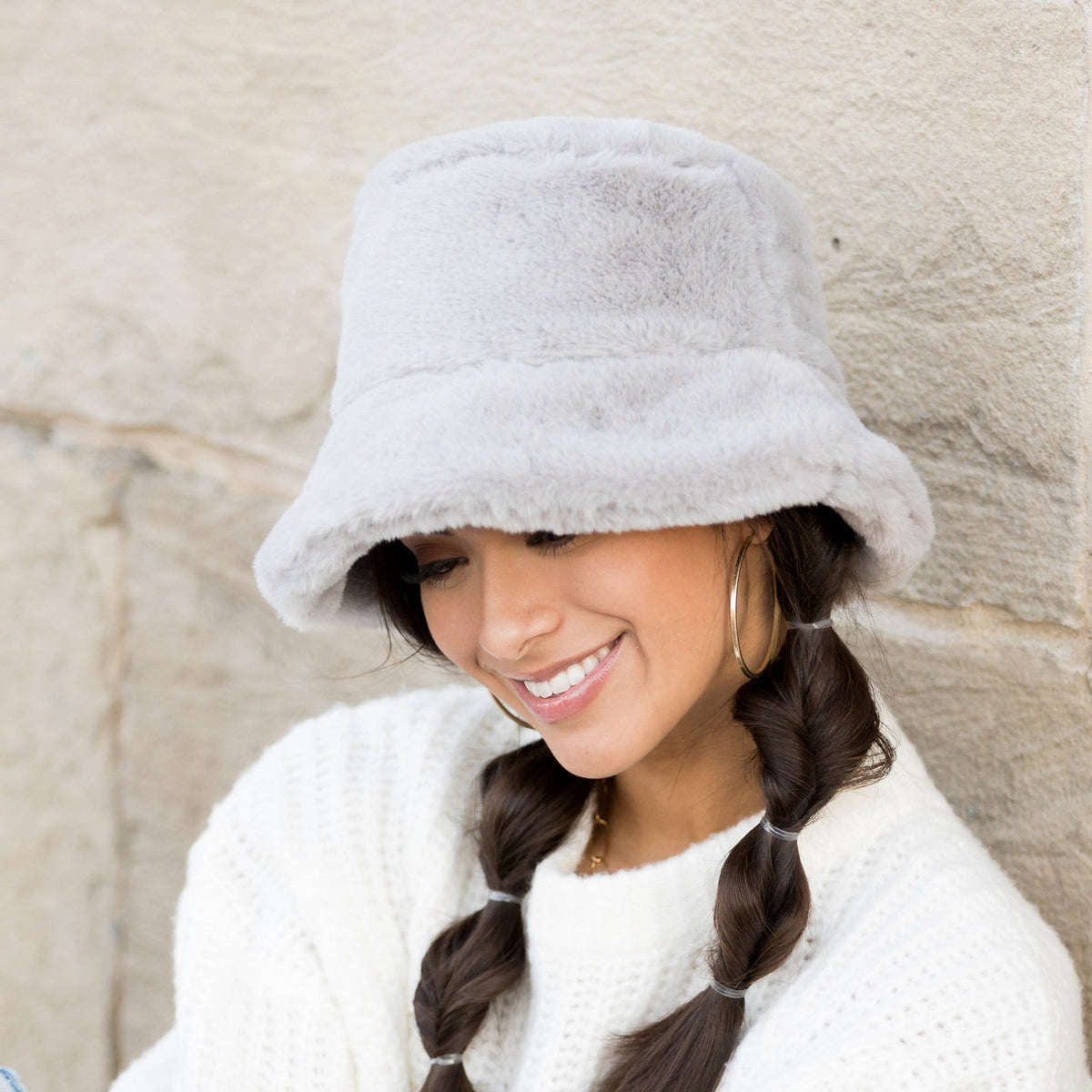 Grey plush bucket hat shown from the front on a model.