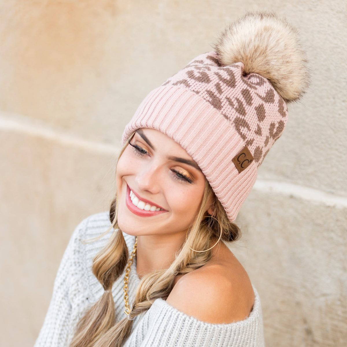 Rose pink leopard-pattern pom beanie worn on a model.