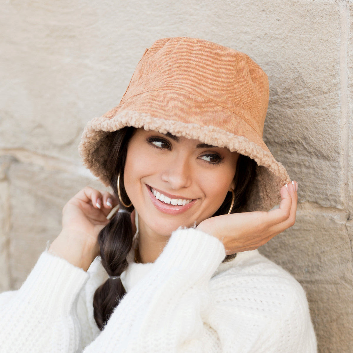 Camel-colored textured reversible bucket hat worn on a model.