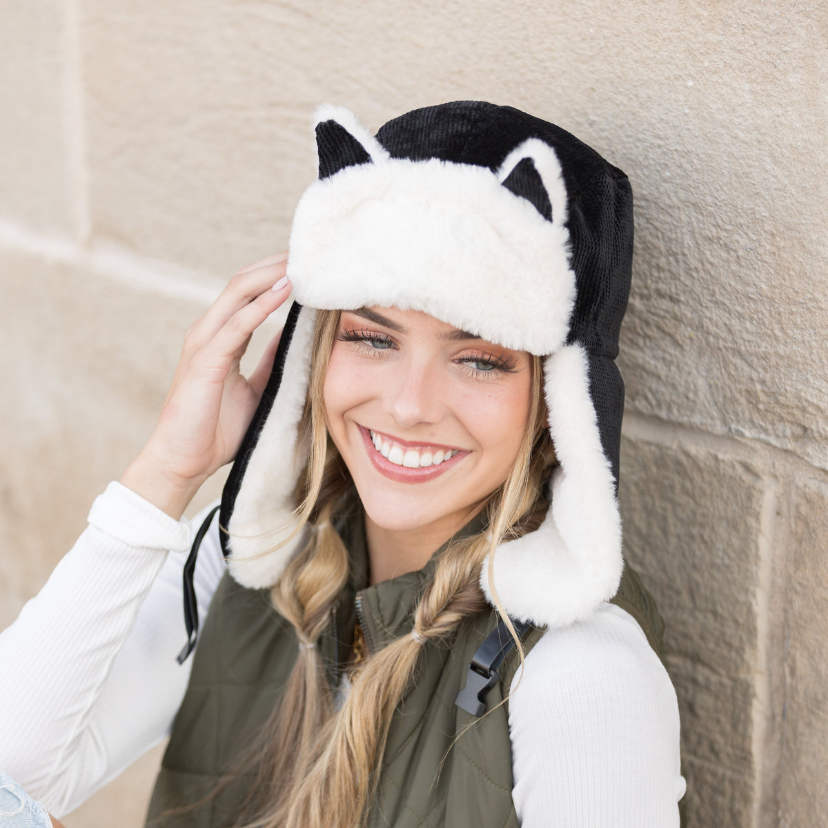 Front view of a black kitten-ear trapper hat.