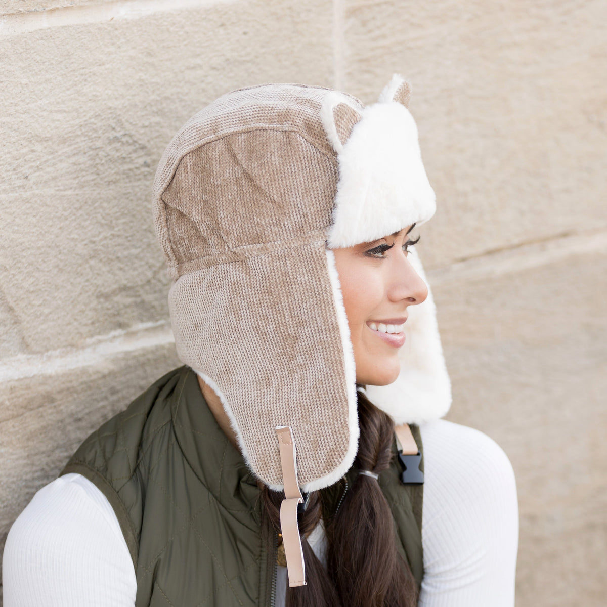 Side view of a taupe kitten-ear trapper hat with long ear flaps.