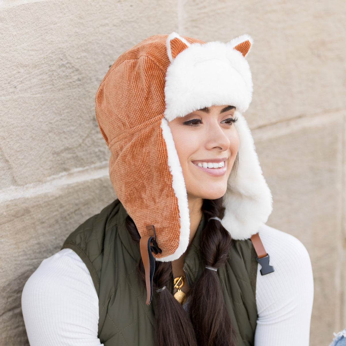 Camel kitten-ear trapper hat with white trim worn on a model.