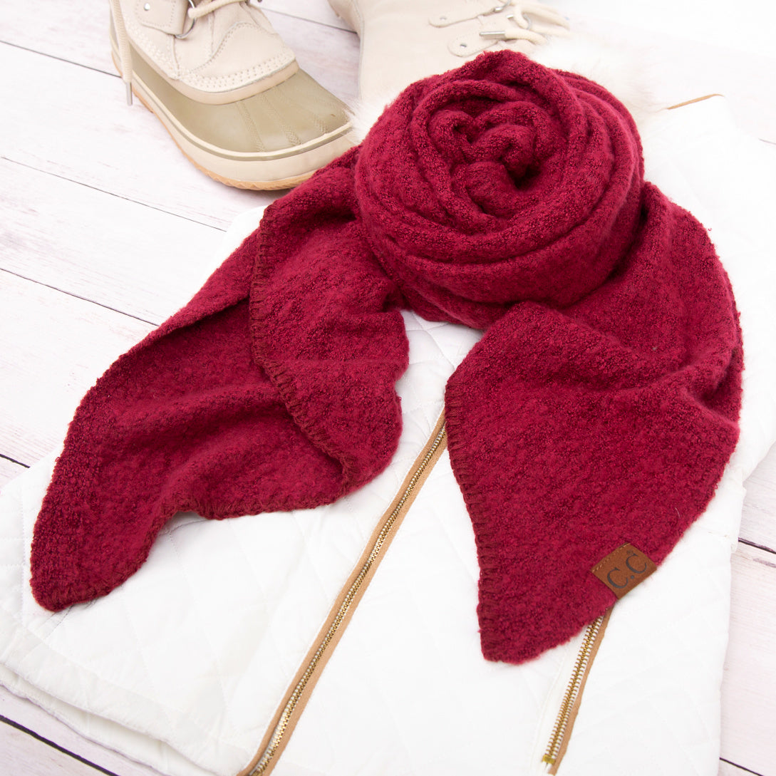 Burgundy scarf arranged beside a beige hat.