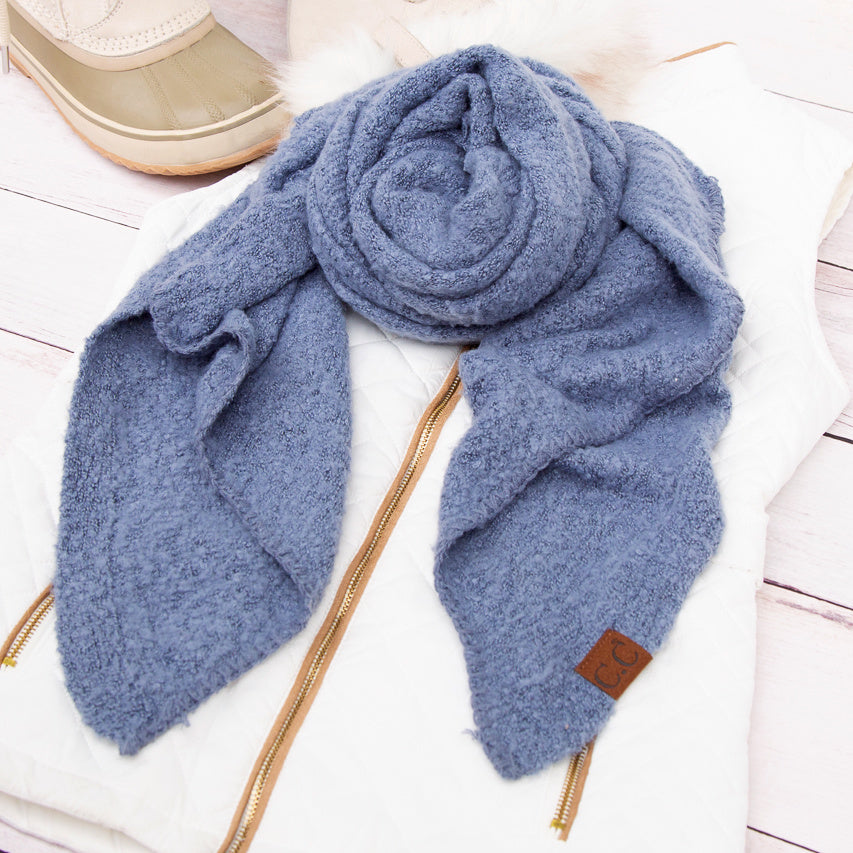 Denim blue scarf arranged beside a beige hat.