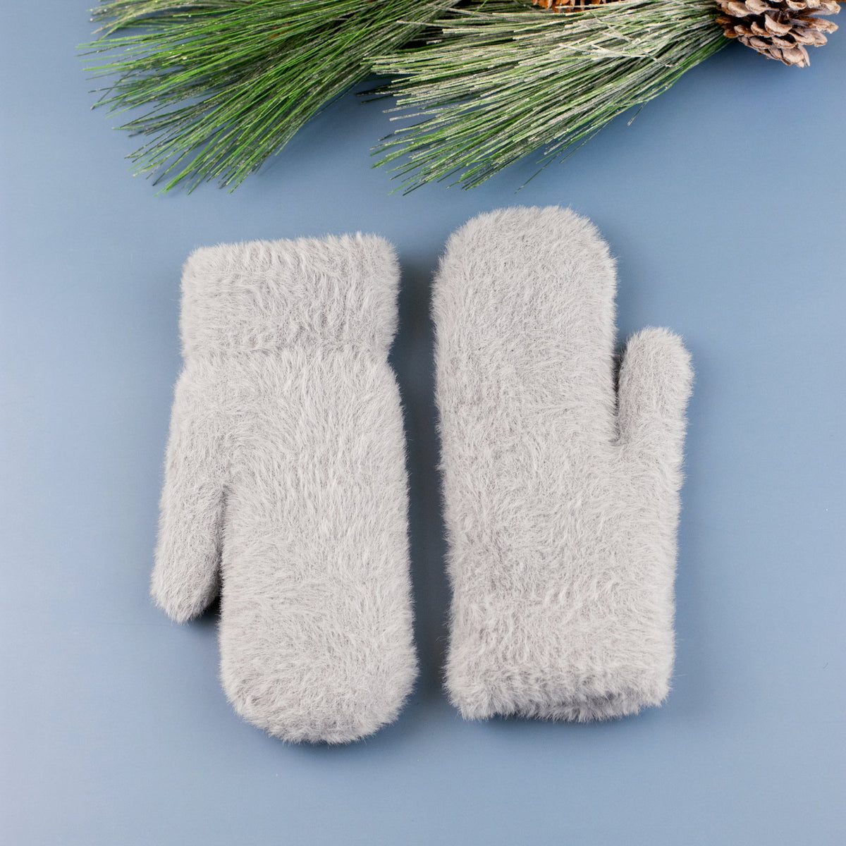 Grey plush mittens displayed on a blue background.