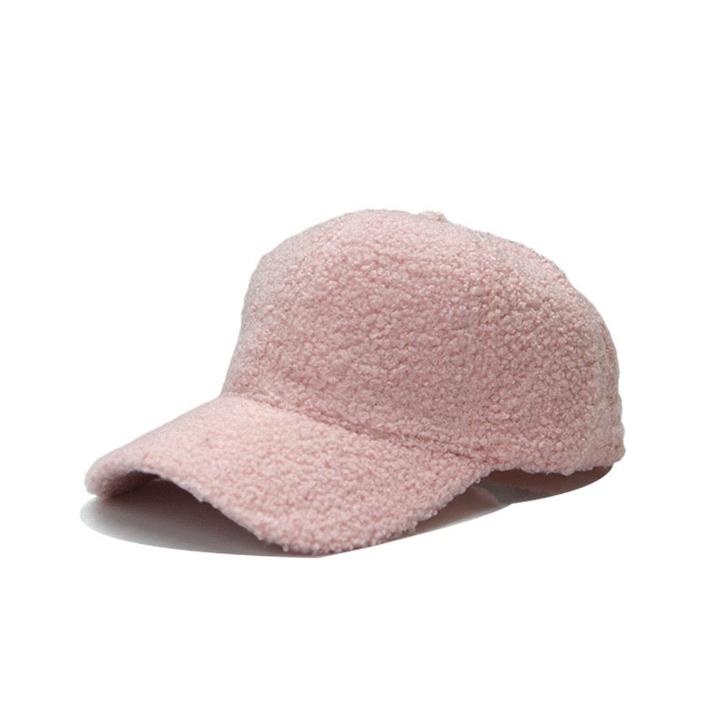 Blush pink textured baseball cap on a white background.