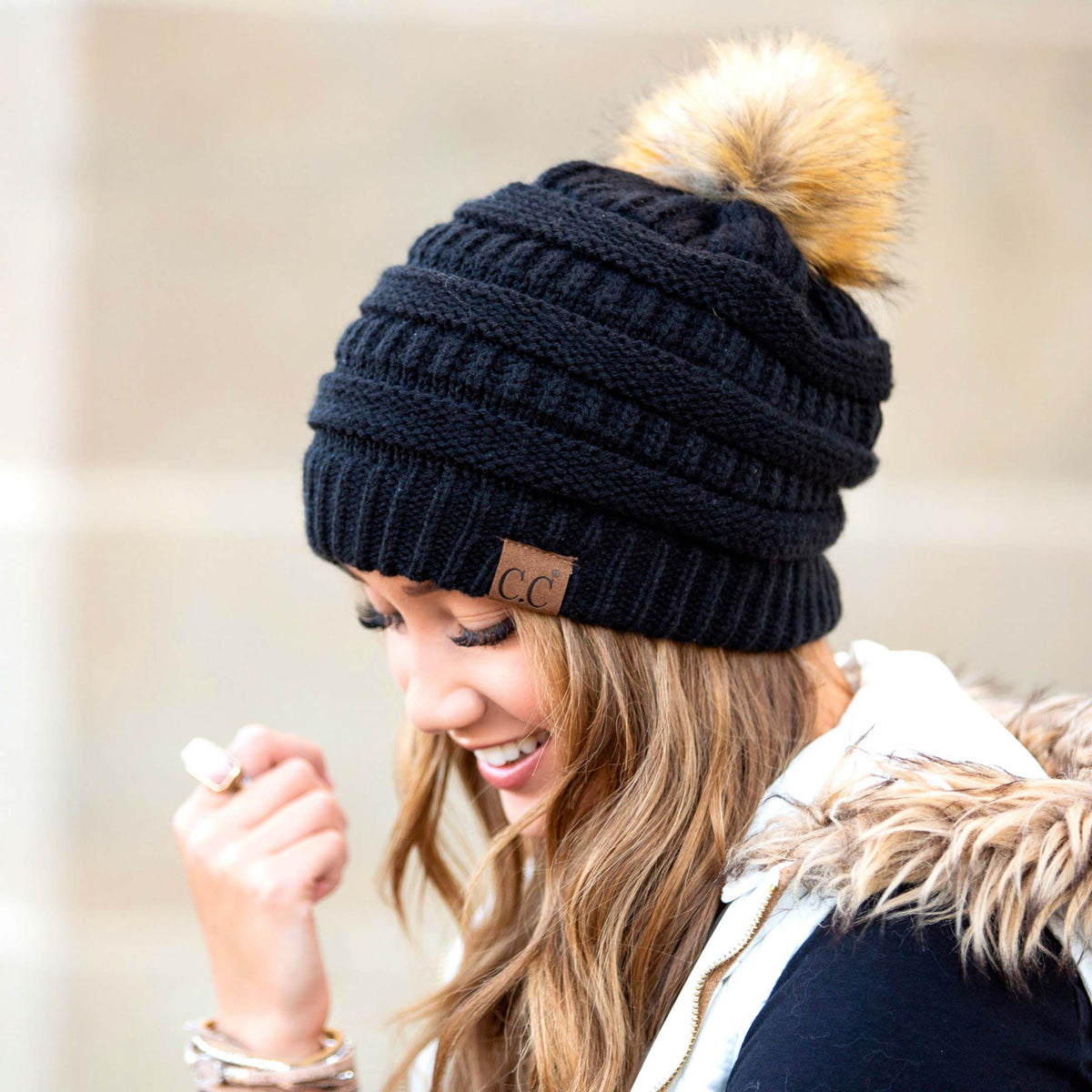 Dark textured knit pom beanie worn on a model.