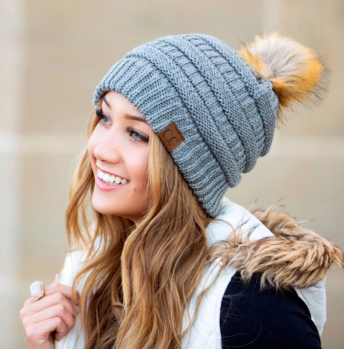Grey textured knit pom beanie worn on a model.