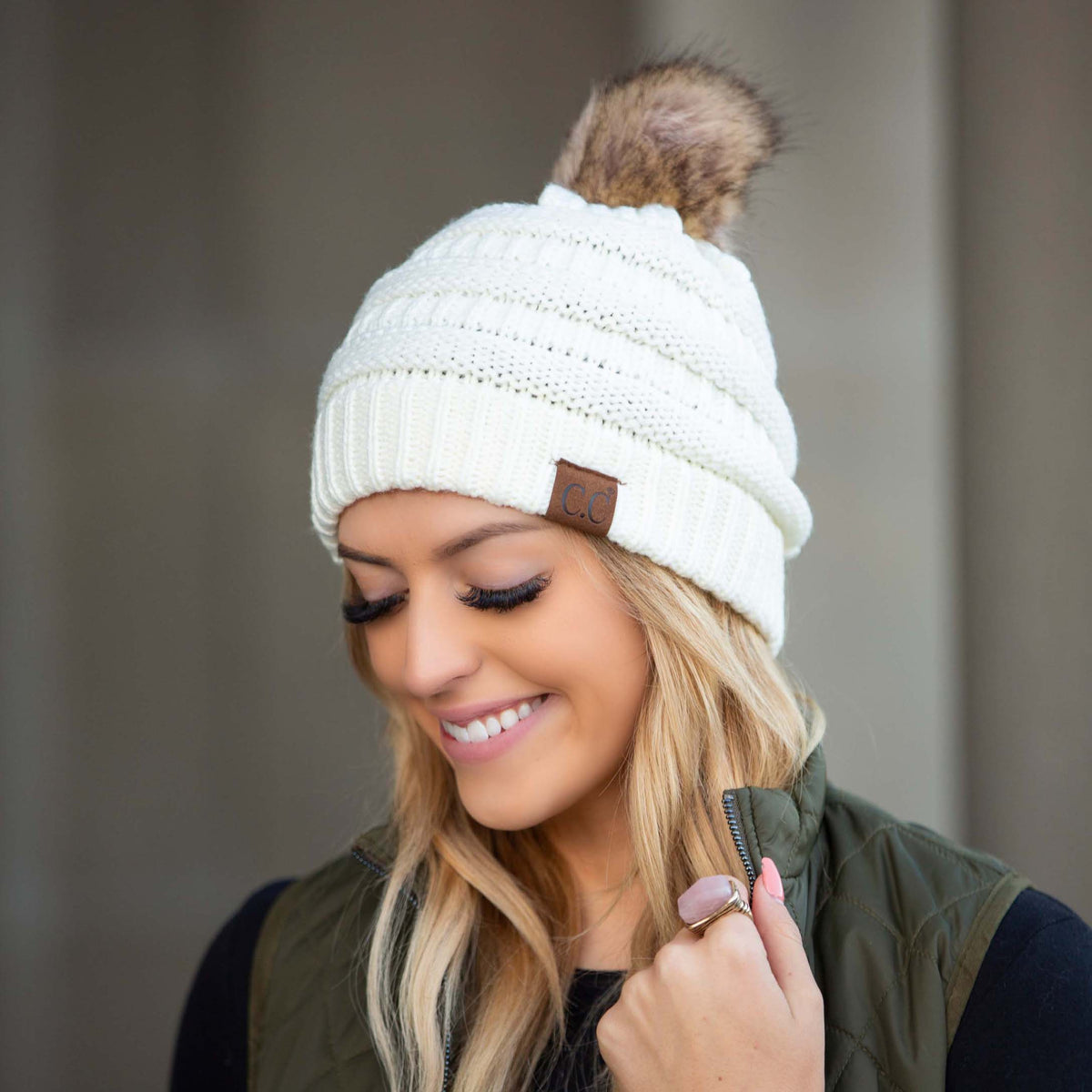 White textured knit pom beanie worn on a model.
