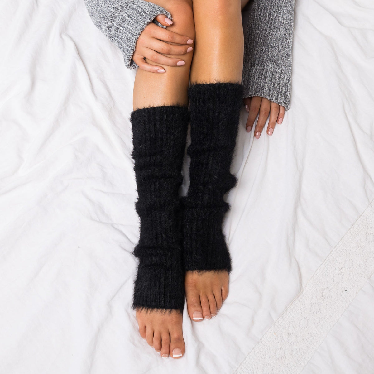 Black fuzzy leg warmers shown from above.