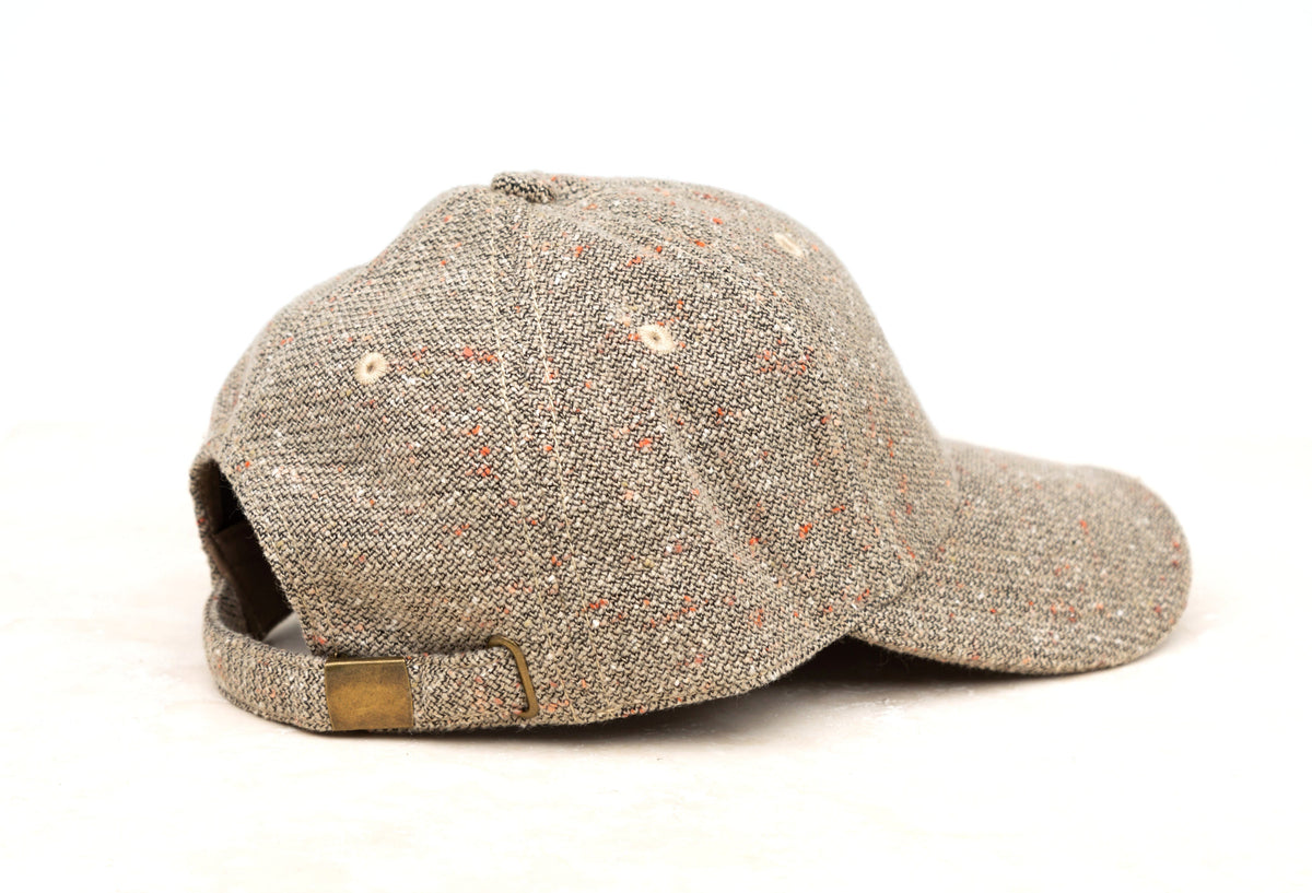 Beige tweed-style baseball cap shown from the side on a white background.