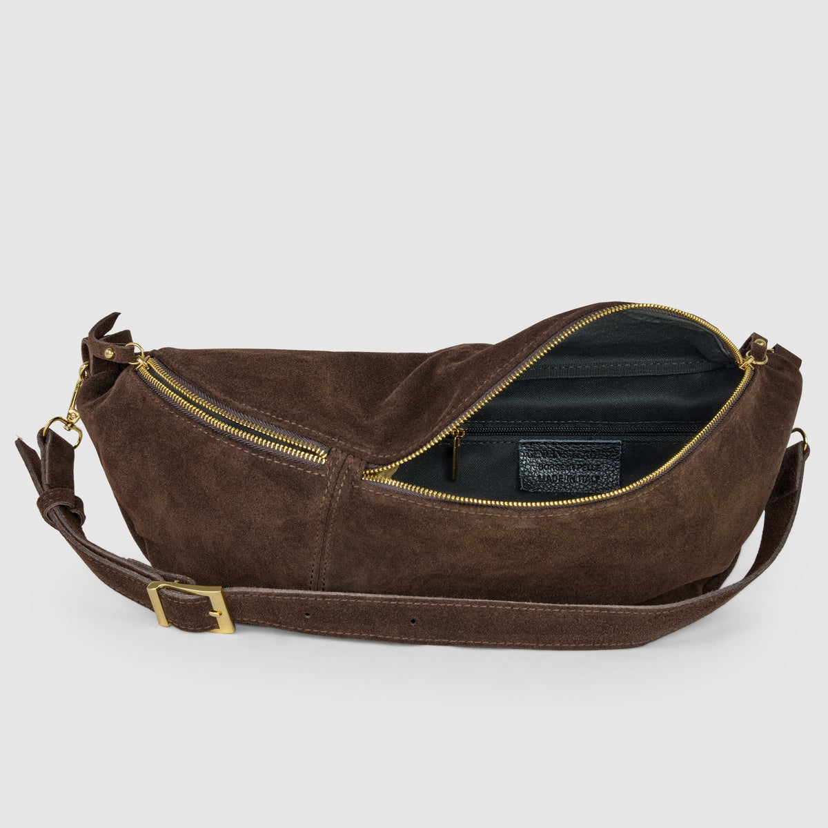 Open chocolate suede crescent bag showing black lining and an interior zip pocket.