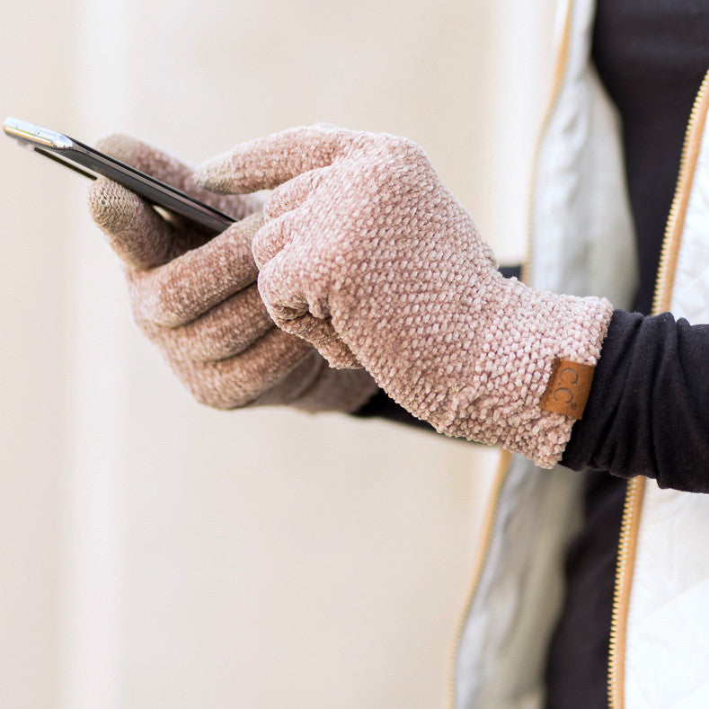 Taupe textured gloves worn while holding a phone.