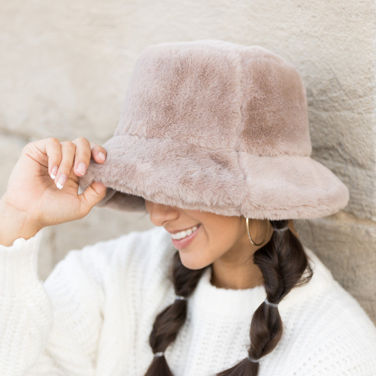 Taupe plush bucket hat worn with the brim lowered.