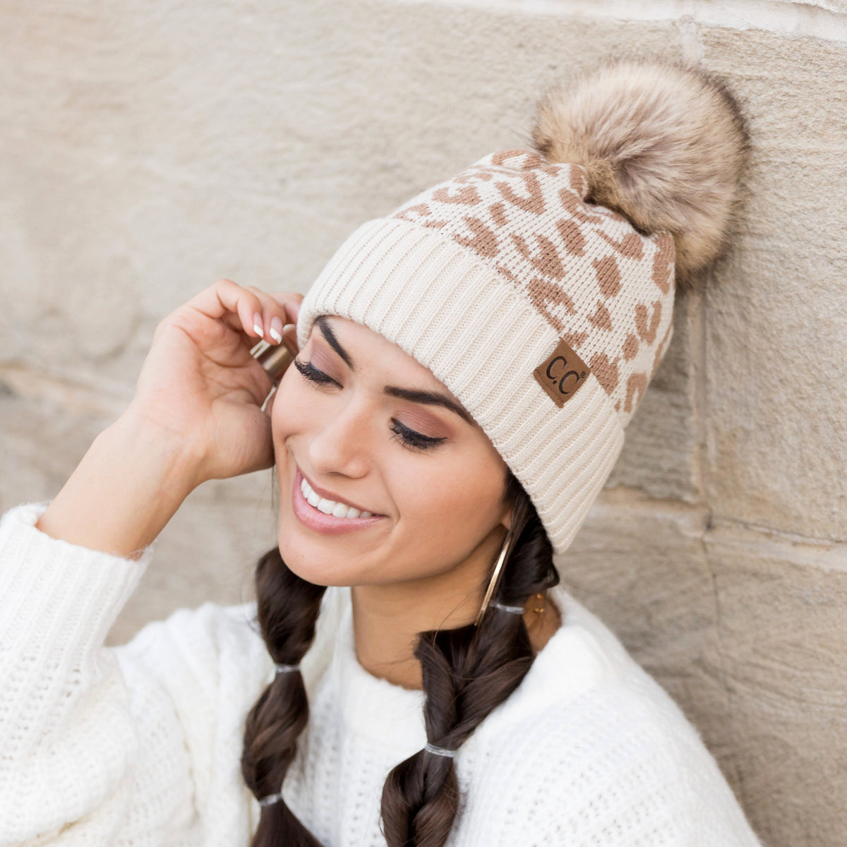 Beige leopard-pattern pom beanie worn on a model.