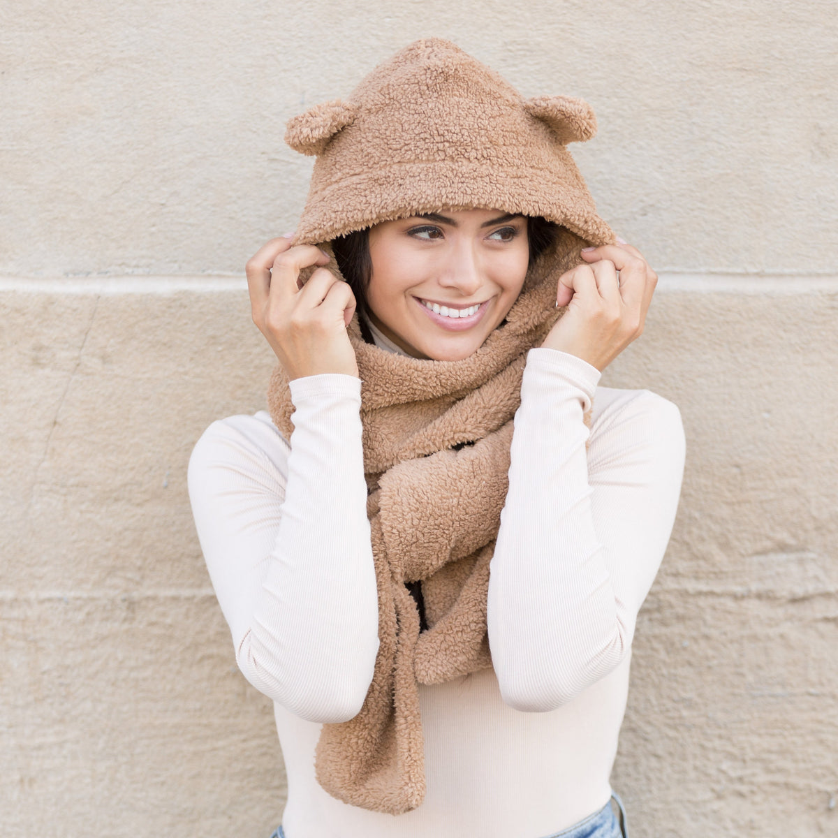 Camel-colored plush hooded scarf with bear-ear details worn on a model.