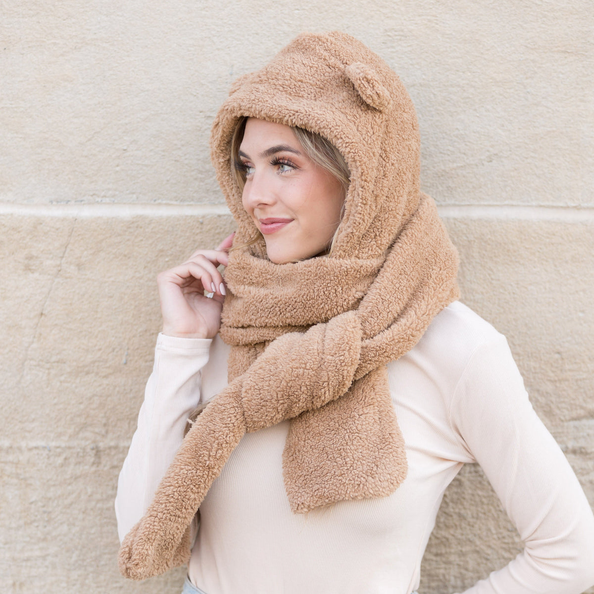 Side view of a camel-colored plush hooded scarf.