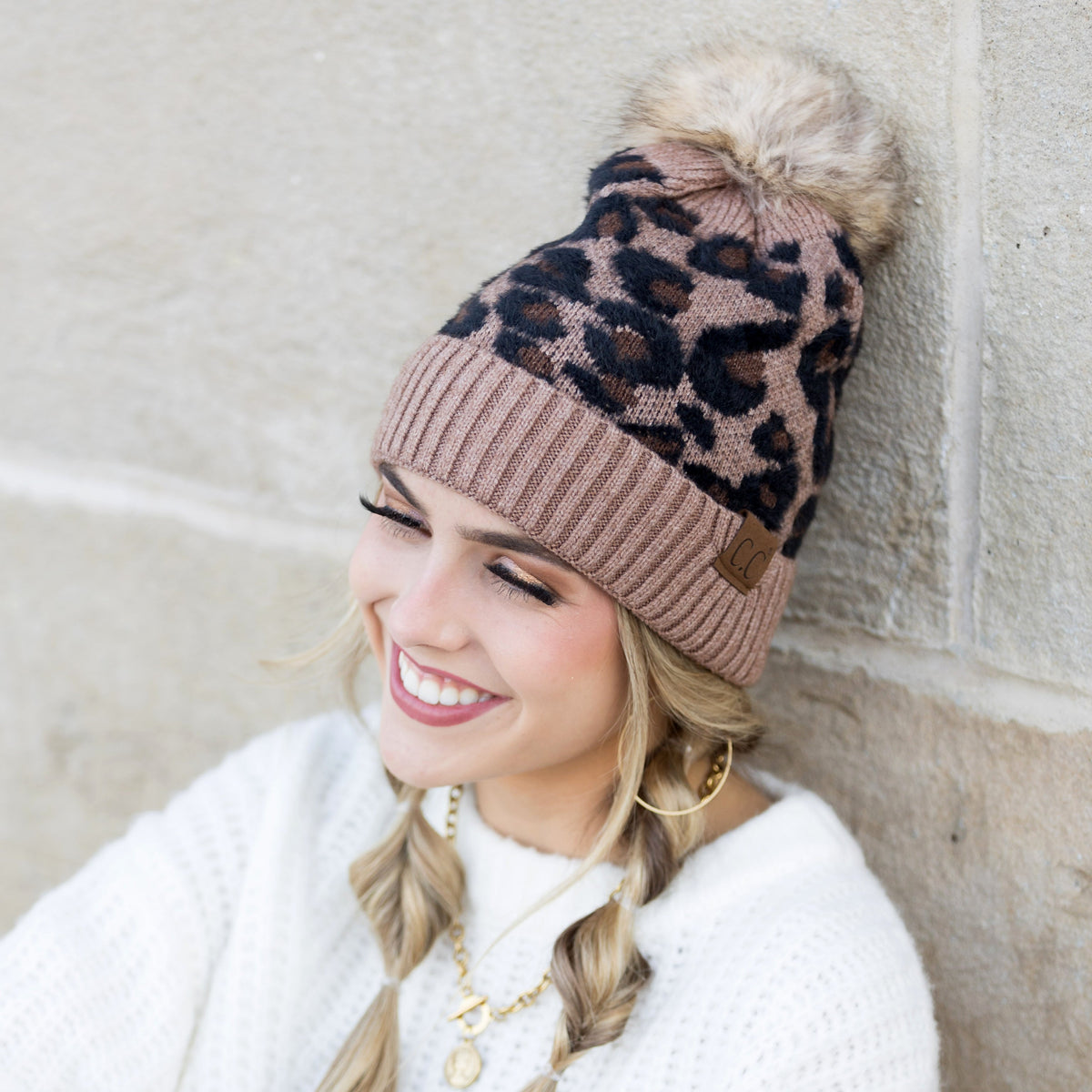 Brown and black leopard-print pom beanie worn on a model.