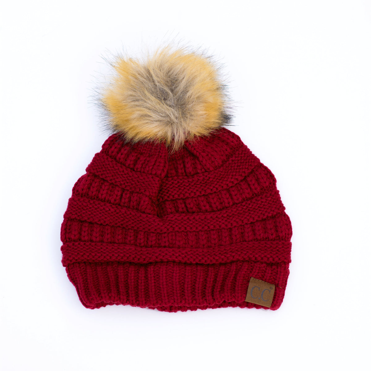 Burgundy knit pom beanie on a white background.
