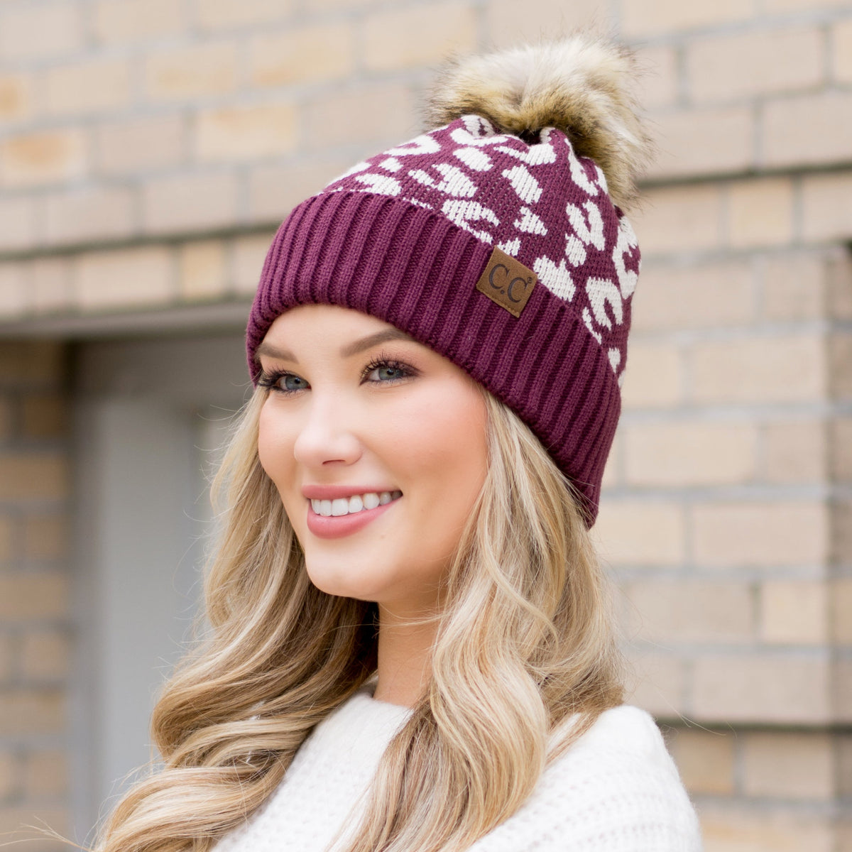 Burgundy leopard-pattern pom beanie shown from the front.