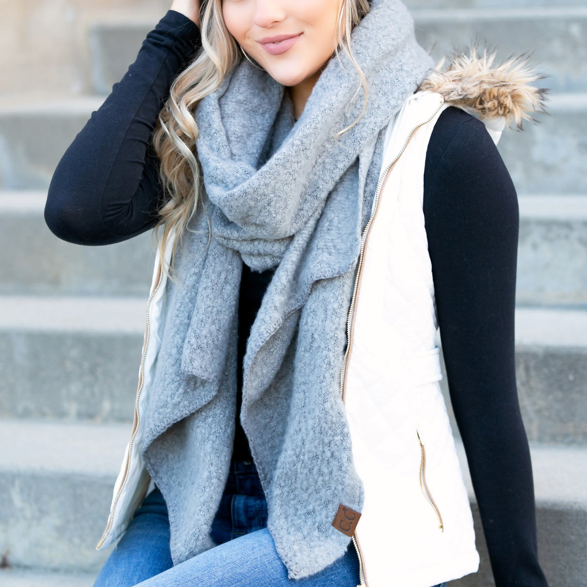 Blue-grey draped scarf worn with a dark jacket.