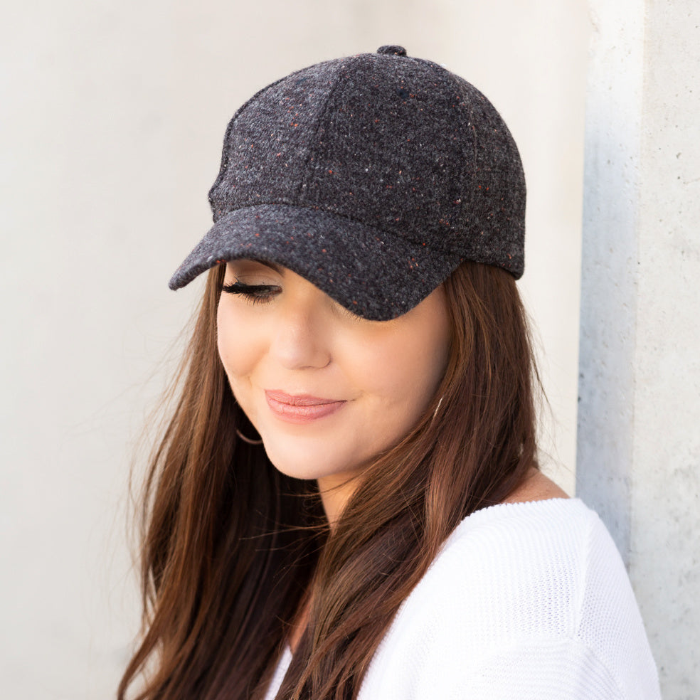 Dark grey tweed-style baseball cap worn on a model.