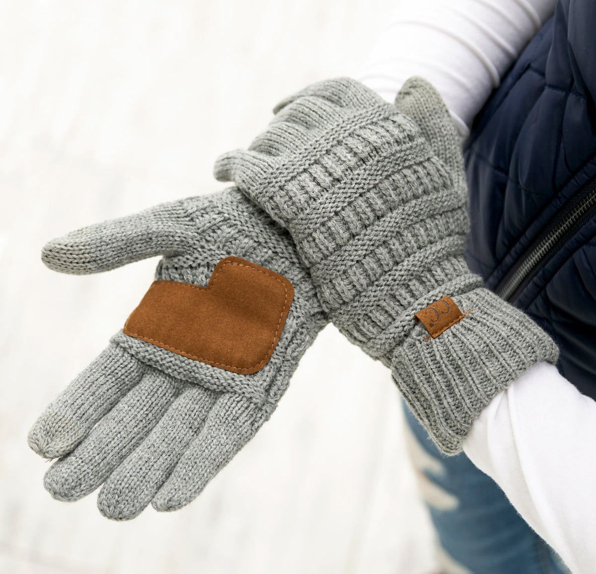 Light grey cable-knit gloves showing contrasting palm details.