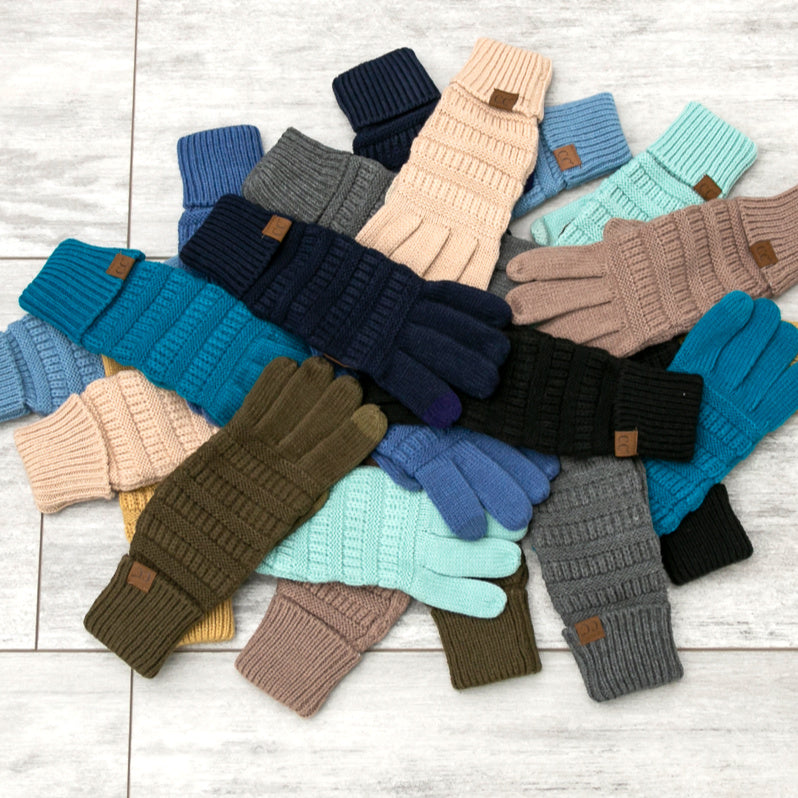 Cable-knit gloves in several colors arranged together.