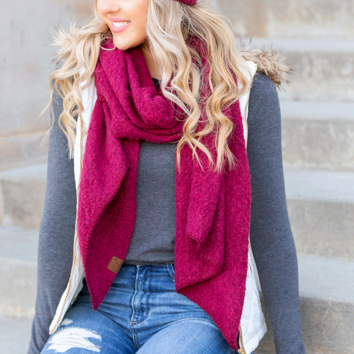 Burgundy draped scarf worn with a dark sweater.
