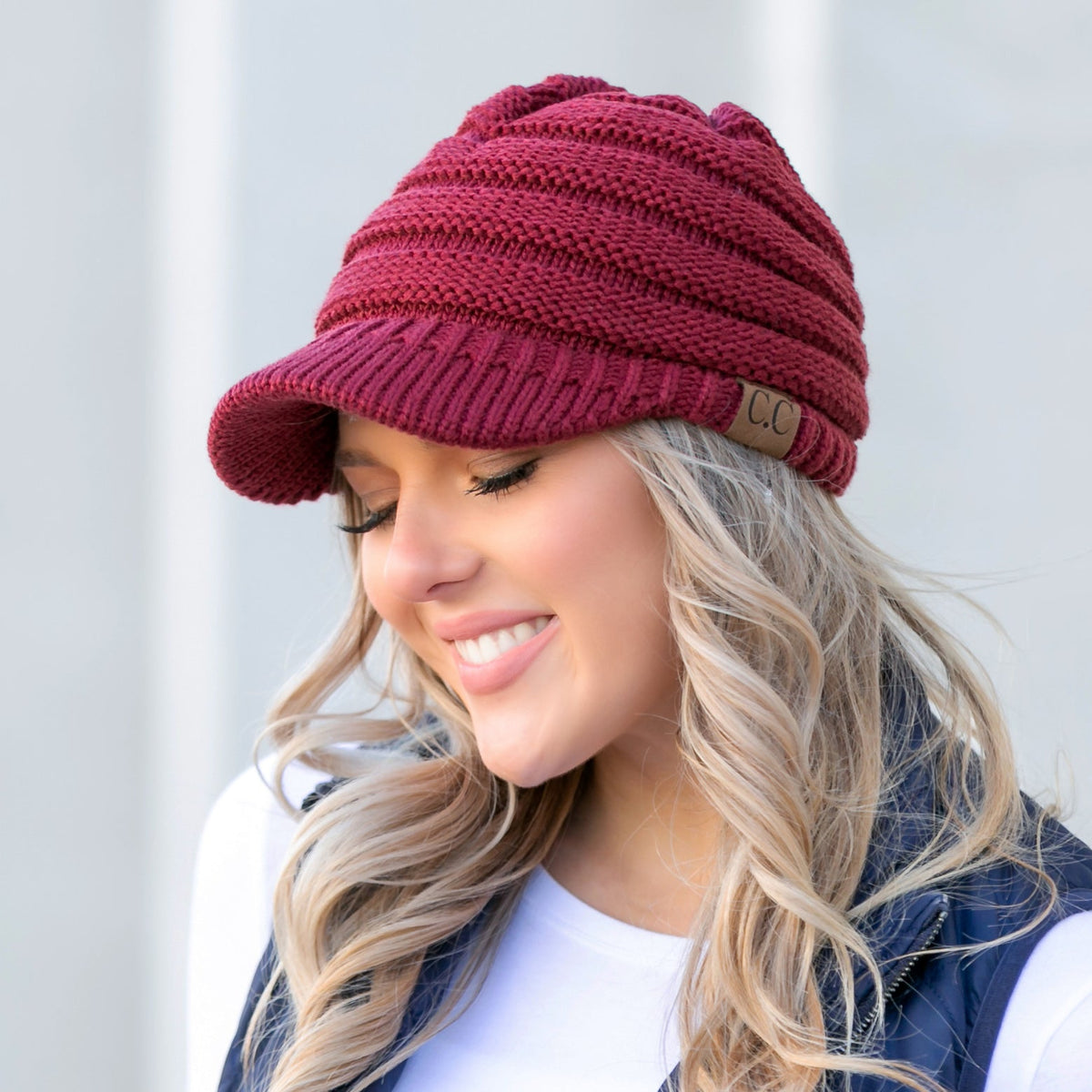 Burgundy knit brimmed cap worn on a model.