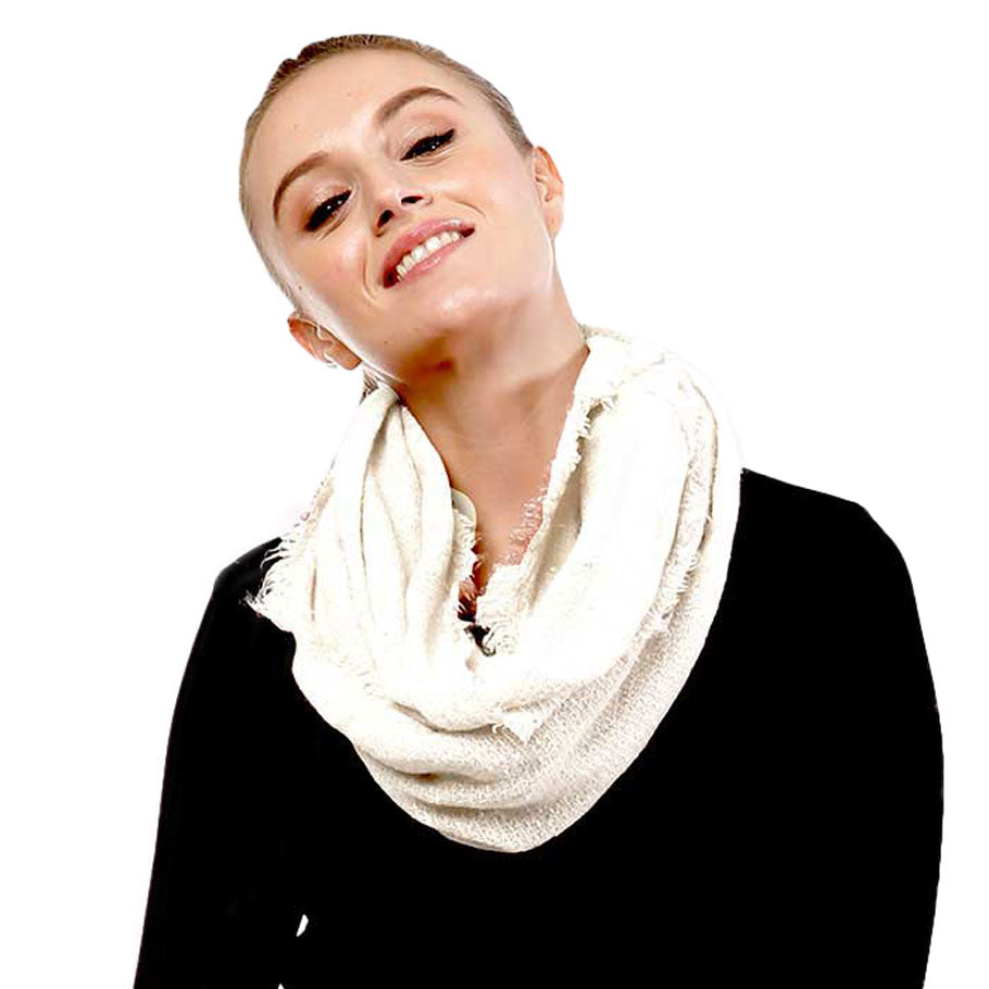 Ivory boucle infinity scarf worn with a black top.