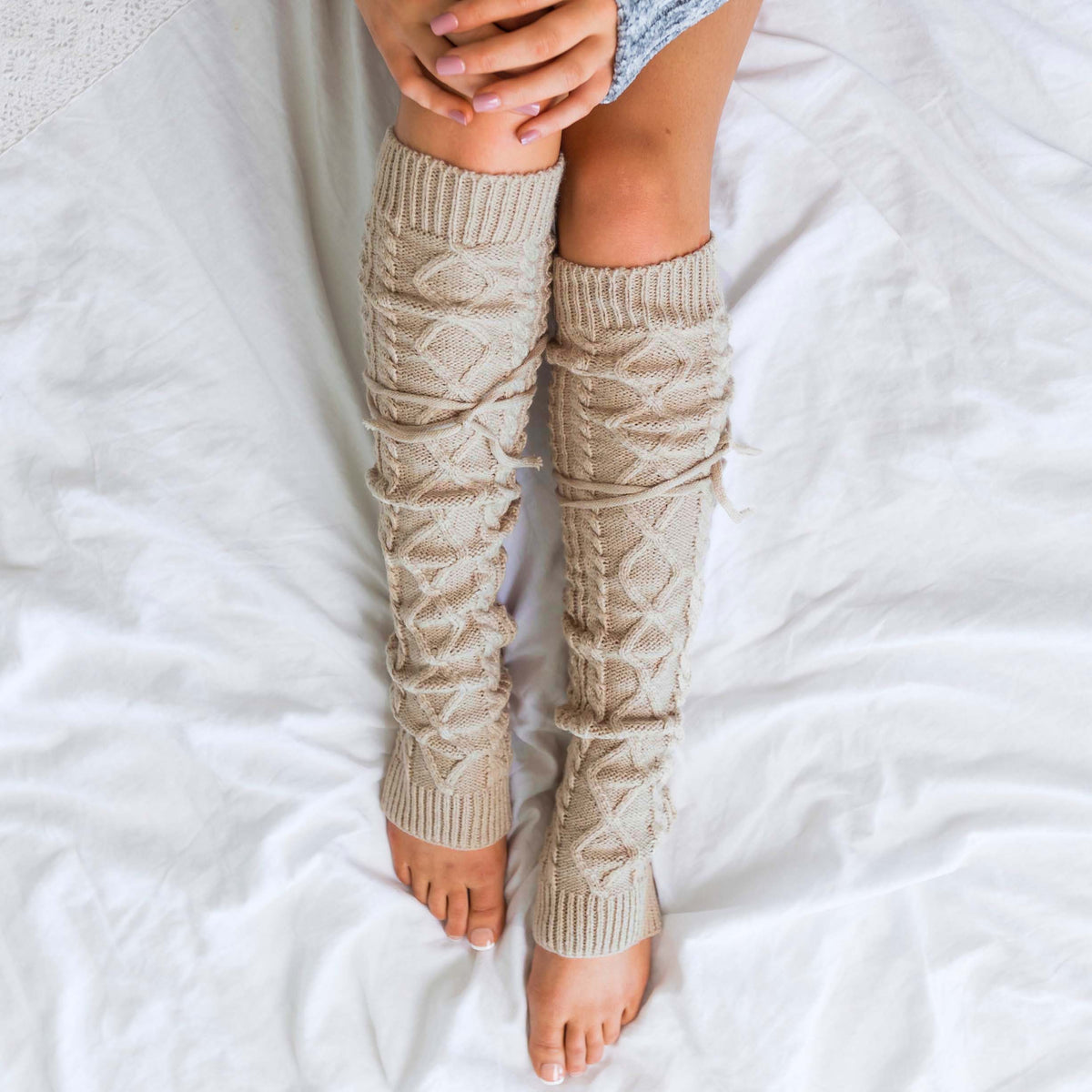 Beige cable-knit leg warmers shown from above.