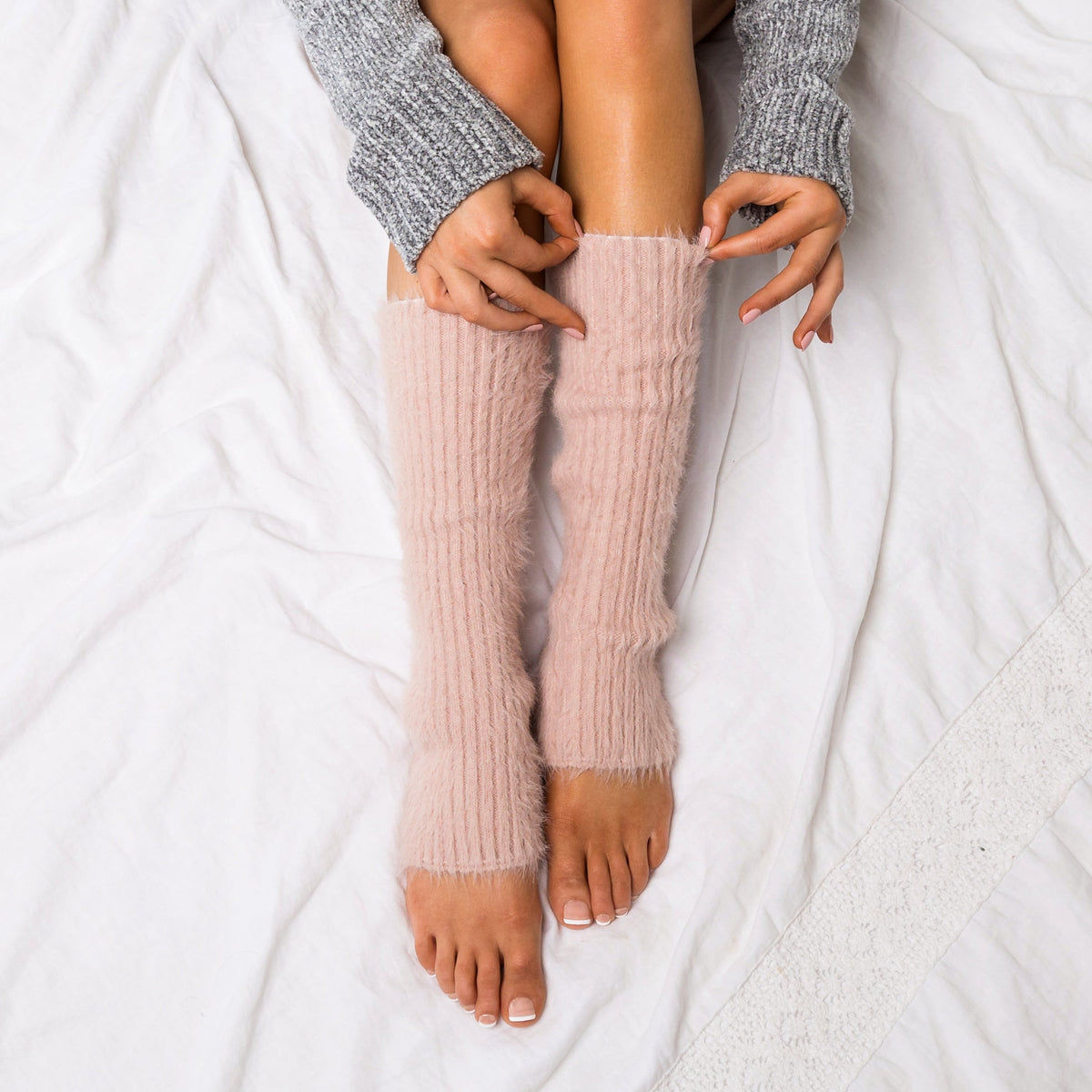 Blush pink fuzzy leg warmers shown from above.