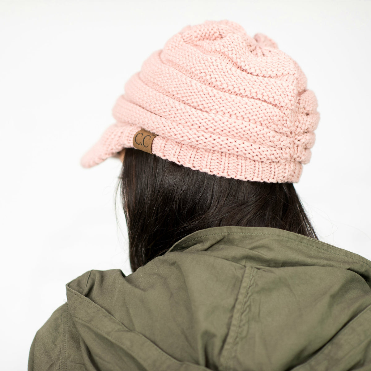 Rear view of a pink knit brimmed cap.