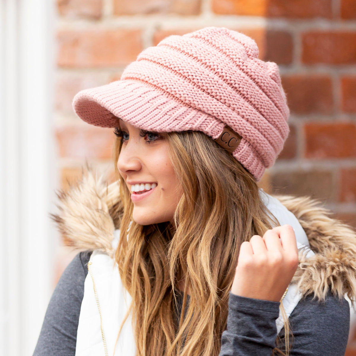 Pink knit brimmed cap shown from the side.