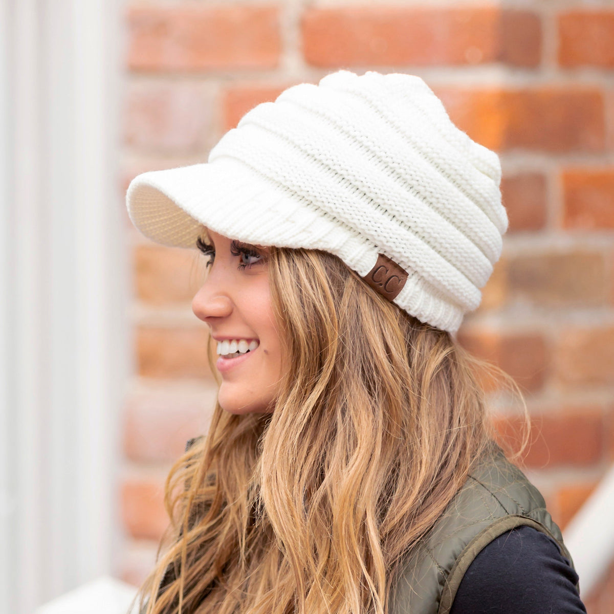 Ivory knit brimmed cap shown from the side.